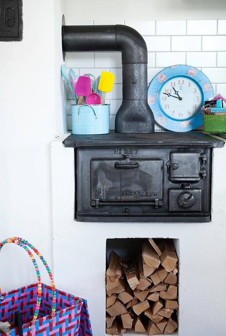 A kitchen with an old cast-iron range with a wood storage below it