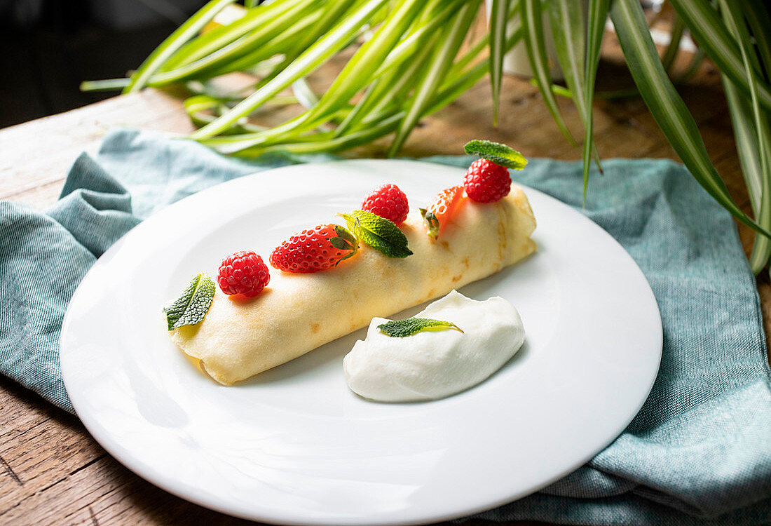 Stuffed crepes with cream, strawberries and raspberries