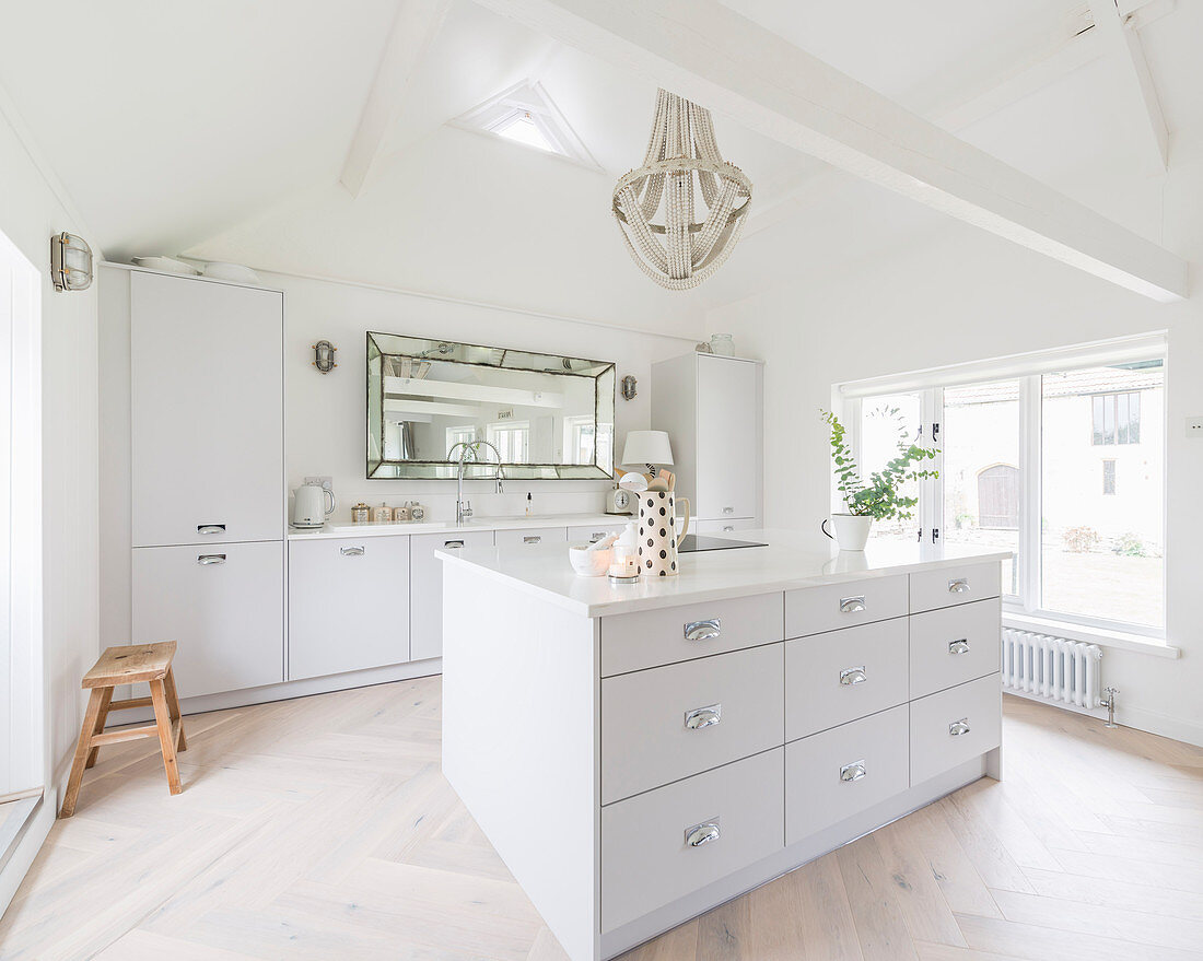 White fitted kitchen with island counter in converted barn