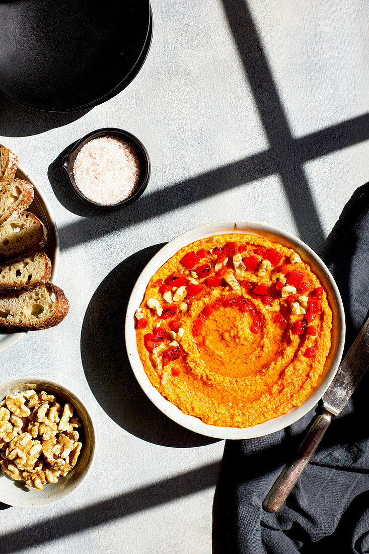 A bowl of homemade red roasted pepper pesto in the sunshine