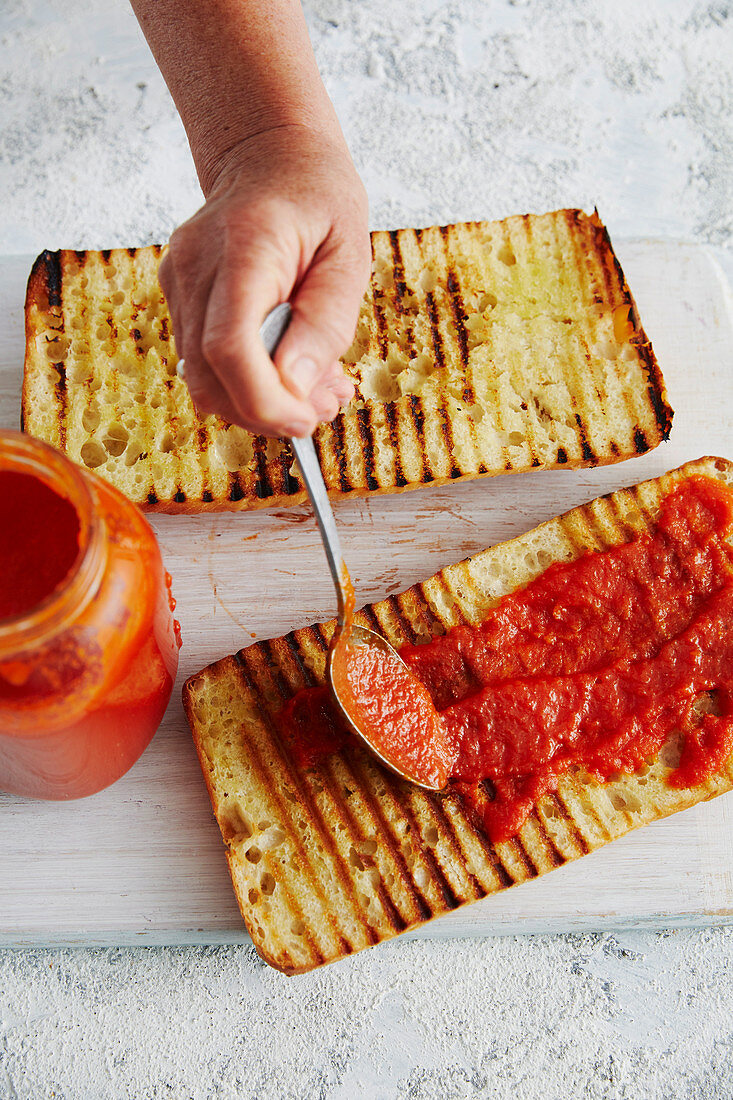 Ciabatta mit Tomatensauce bestreichen