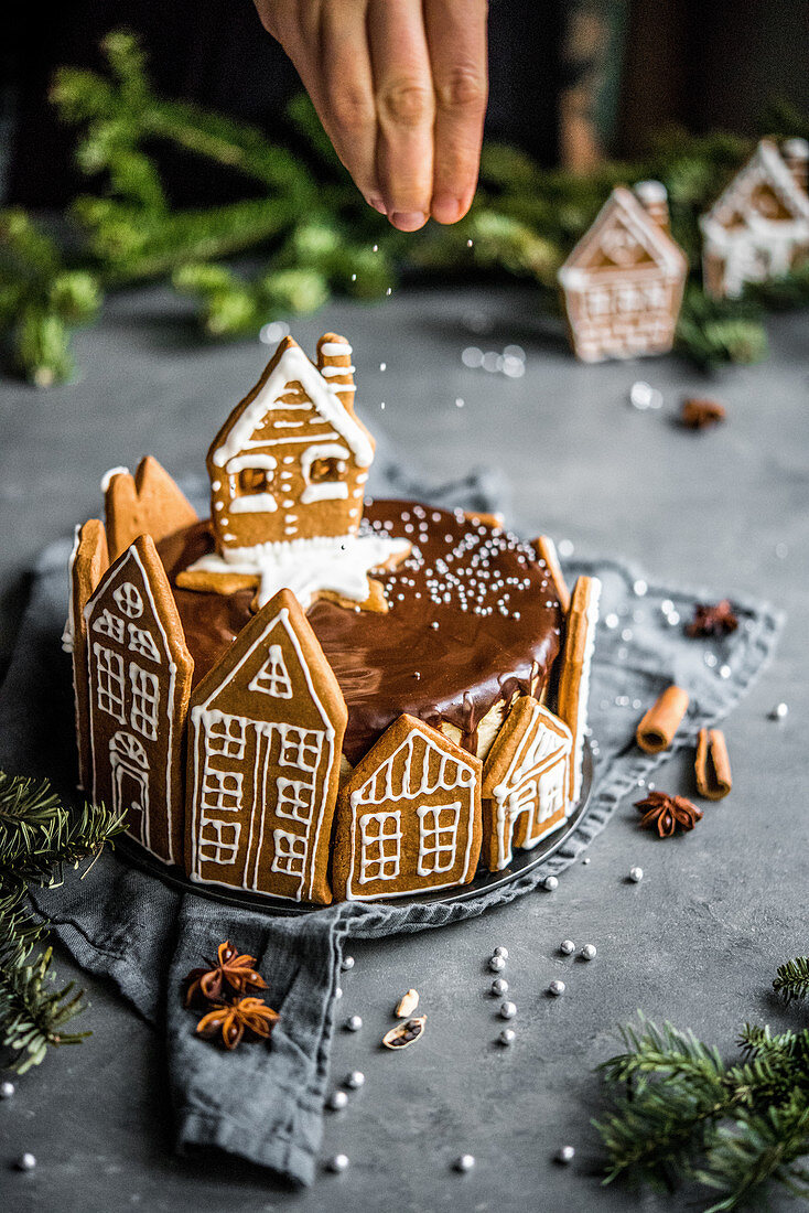 Weihnachtlicher Schoko-Cheesecake dekoriert mit Lebkuchenhäuschen