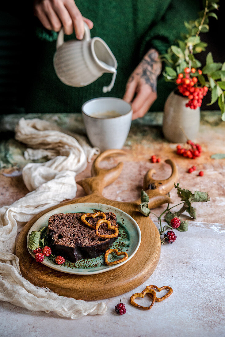Ein Stück Schokoladen-Kastenkuchen dekoriert mit herzförmigen Brezeln
