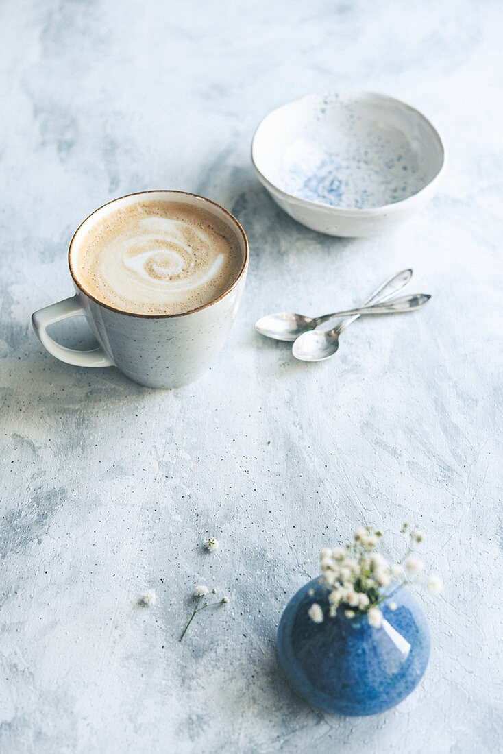 Kaffee mit Milch in Keramiktasse auf hellem Untergrund