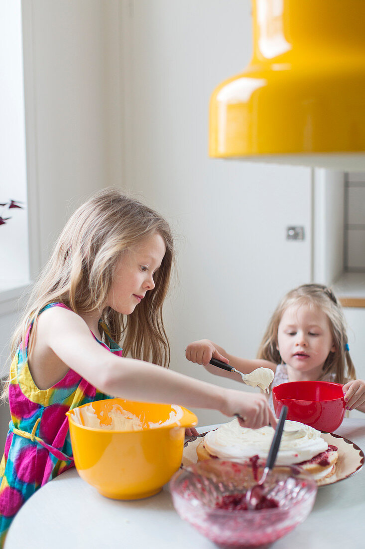 Two girls making a cake