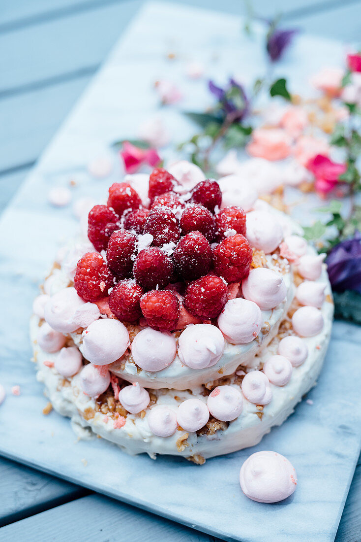 A two-tier meringue cake with raspberries