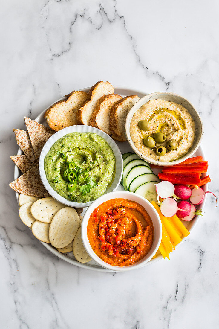 Roasted red bell peppers hummus, jalapeno, avocado and cilantro hummus, provenzal herbs and olives hummus