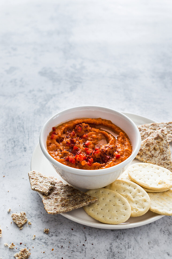 Roter Paprika-Hummus mit Crackern