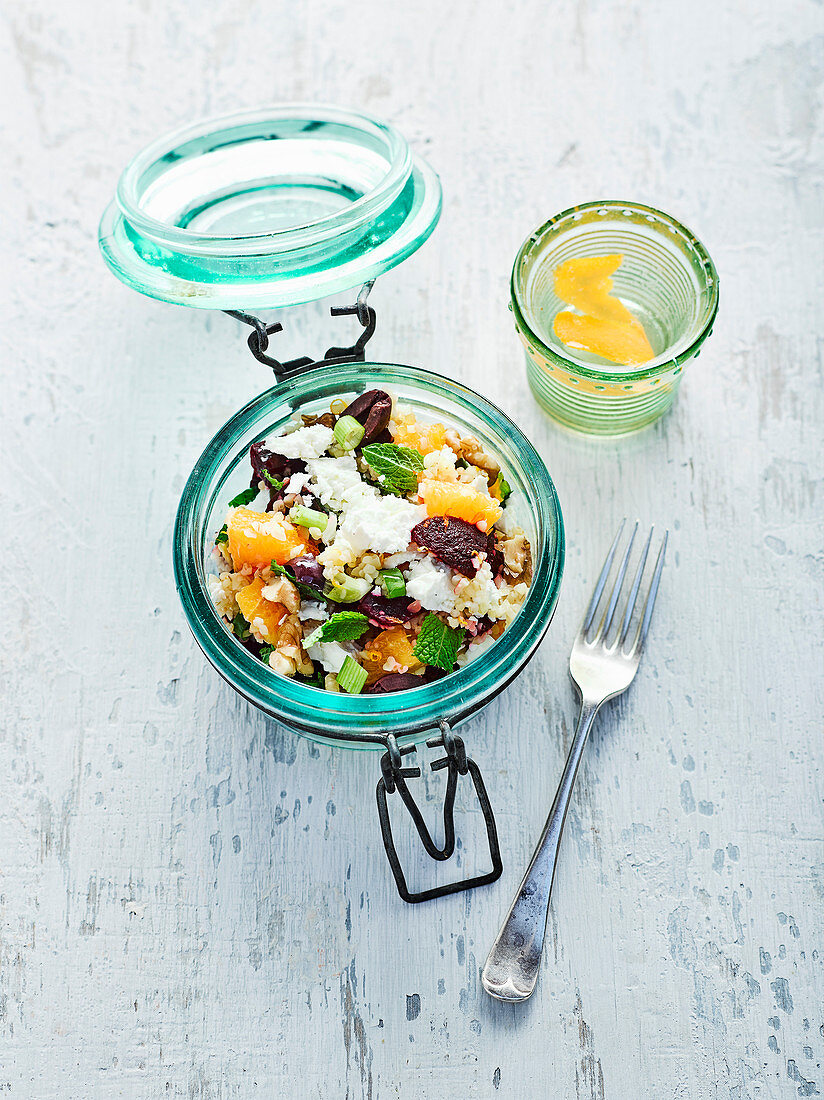Bulgur salad with beetroot and orange segments in a glass jar