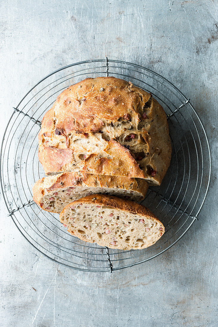 Peppered, no-knead bacon bread, sliced on a wire rack