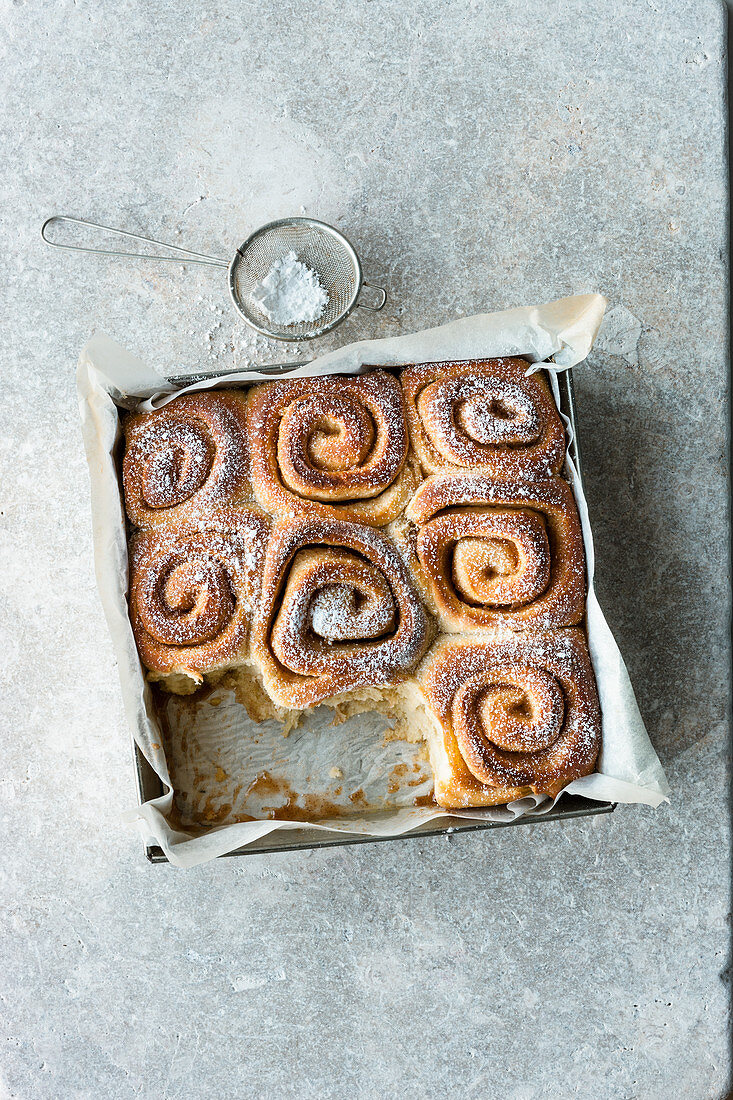 Cinnamon and orange buns in a square baking tin