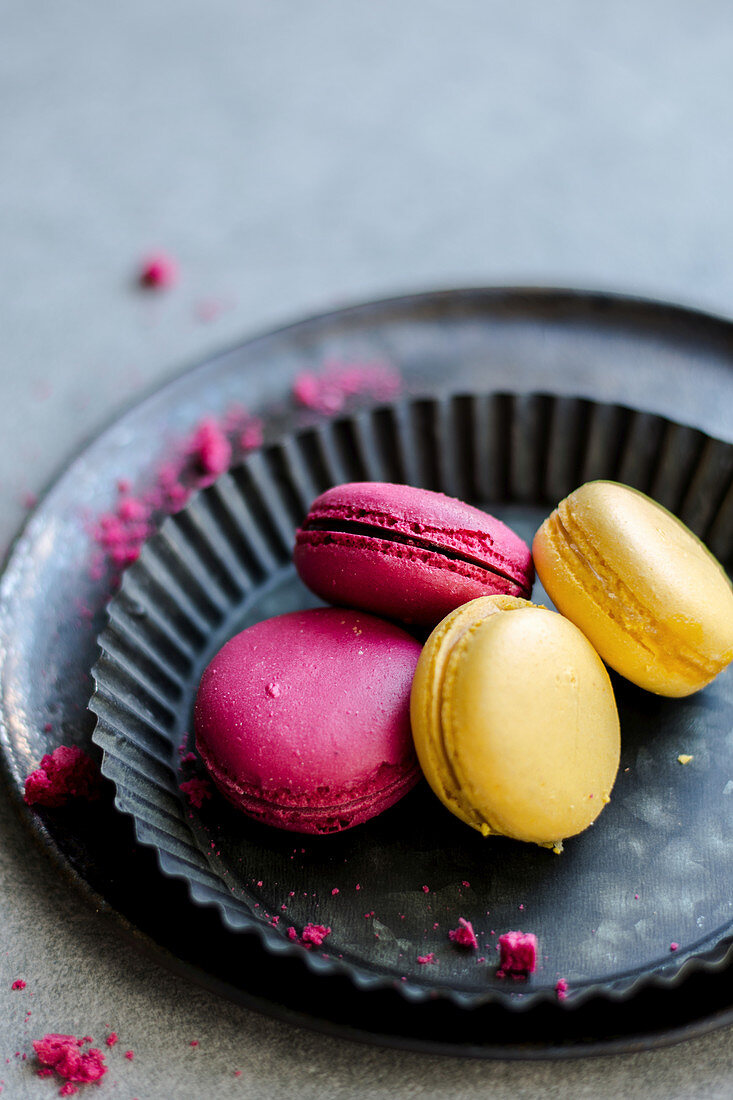 Raspberry and lemon macaroons served on a black tray