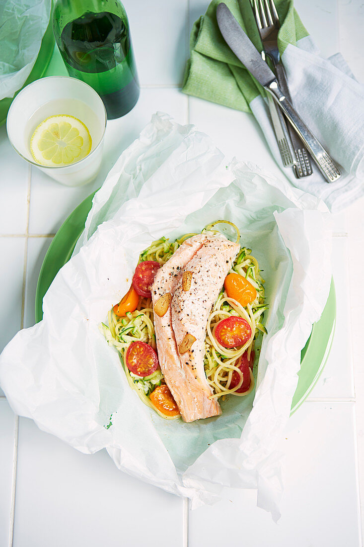 Colourful fish packet with pasta and tomatoes