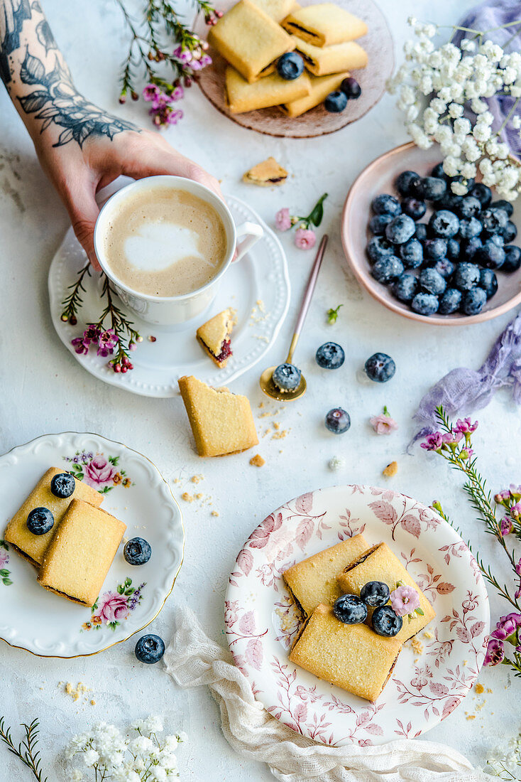 Cookies mit Blaubeermarmeladenfüllung zur Tasse Kaffee