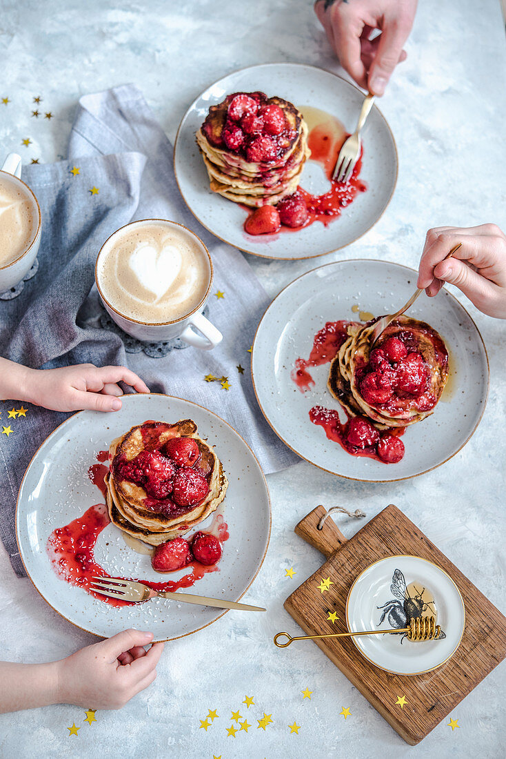 Pancakes mit Erdbeeren und Honig zum Familienfrühstück