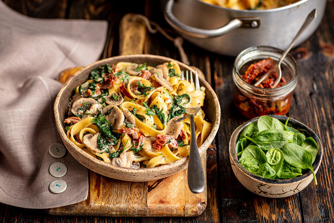 Bandnudeln mit Champignons, getrockneten Tomaten, Spinat und Käse