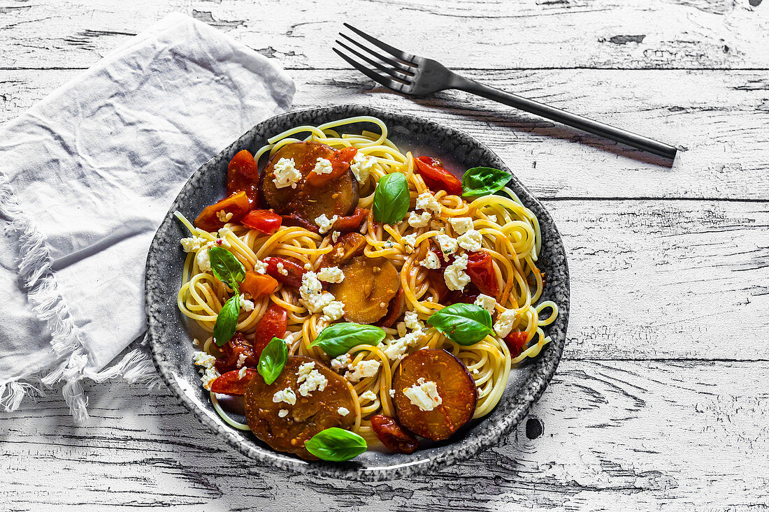 Spaghetti mit gebratenen Zucchinischeiben, Tomaten, Feta und Basilikum