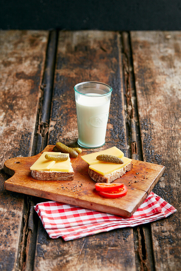 Bauernfrühstück mit Käsebrot, Essiggurken und Glas Milch