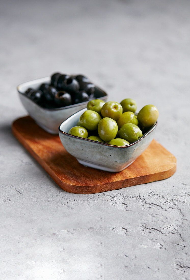Green and black olives in small bowls