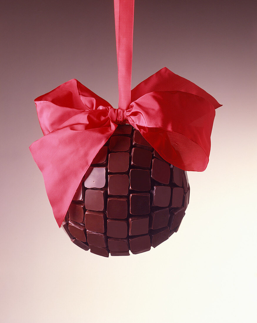 A chocolate ball with a red bow