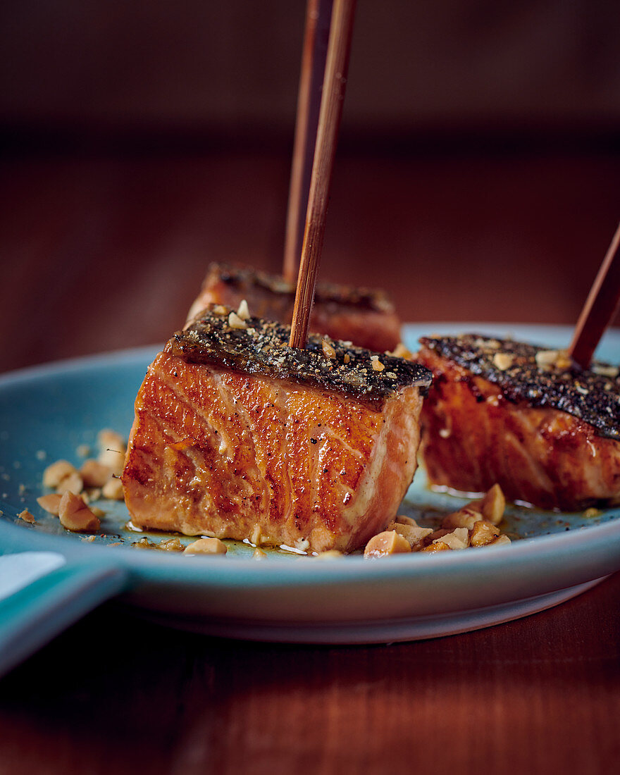 Salmon cubes with coffee crust, ginger, thyme honey and peanuts