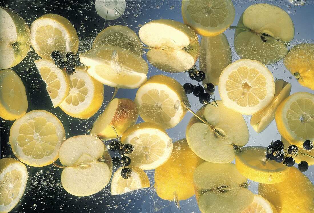 Zitronen-, Apfelstücke & Johannisbeeren in sprudelndem Wasser
