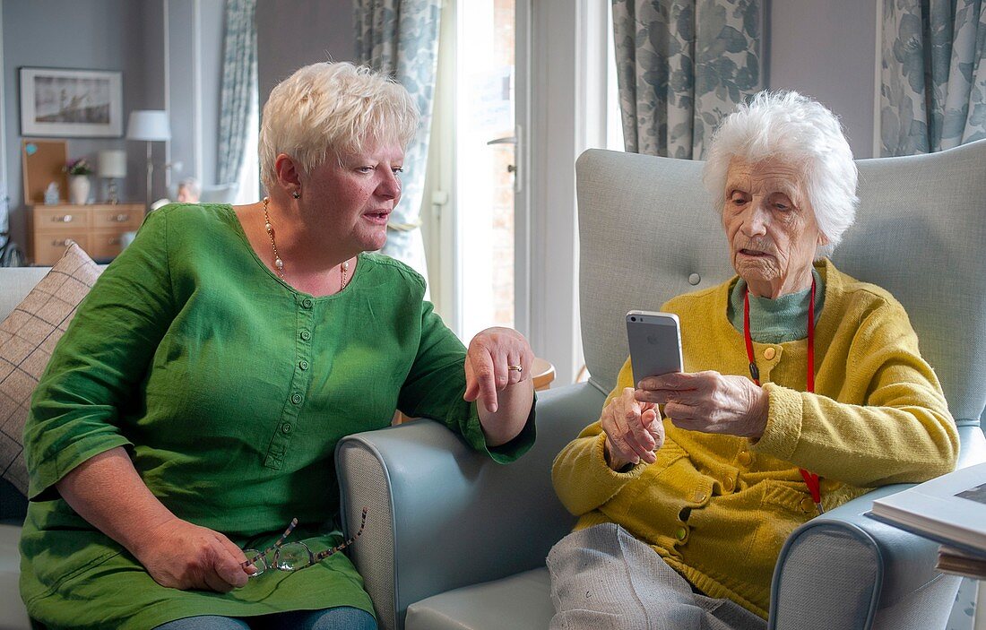 Care home resident looking at smartphone photos