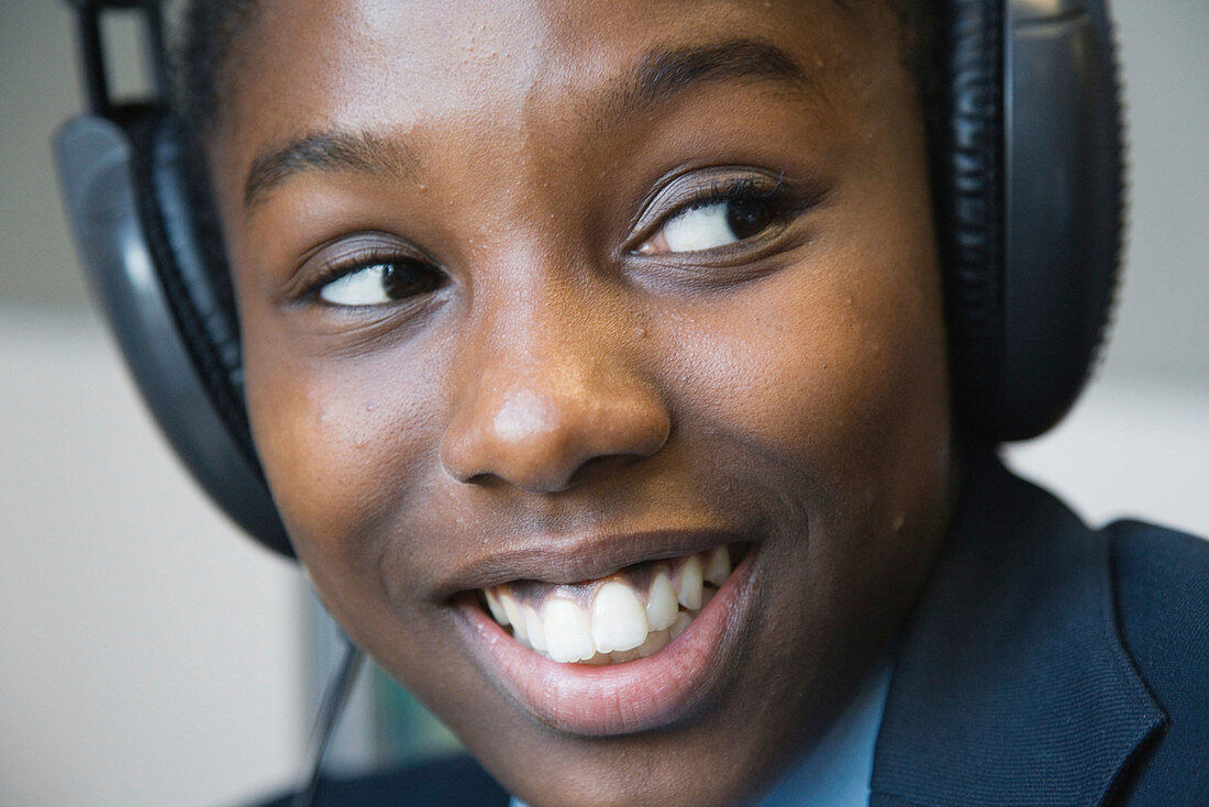Secondary school student listening to headphones