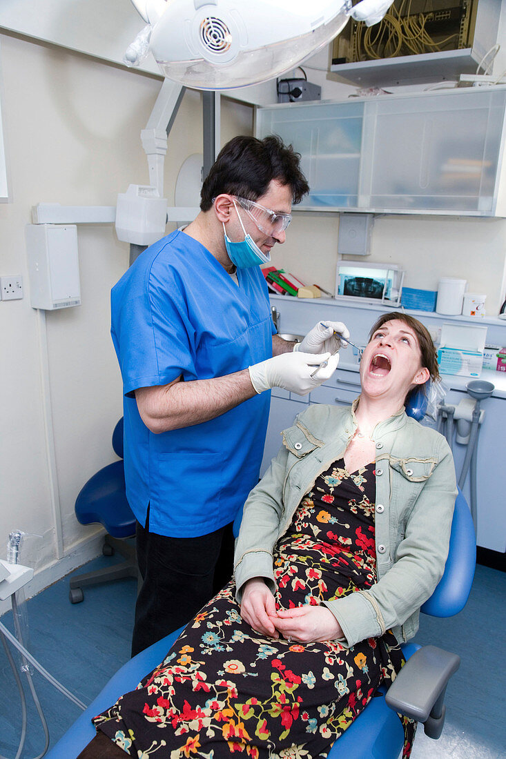 Dentist carrying out dental treatment on a patient