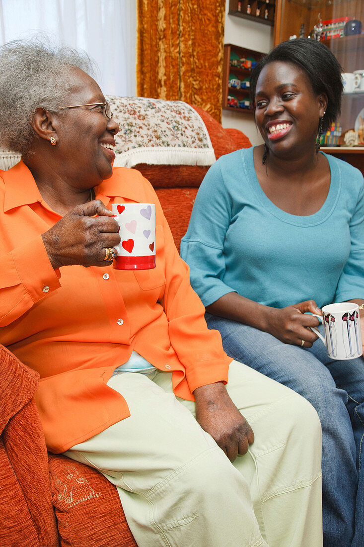 Daughter and mother having a laugh over a cup of tea