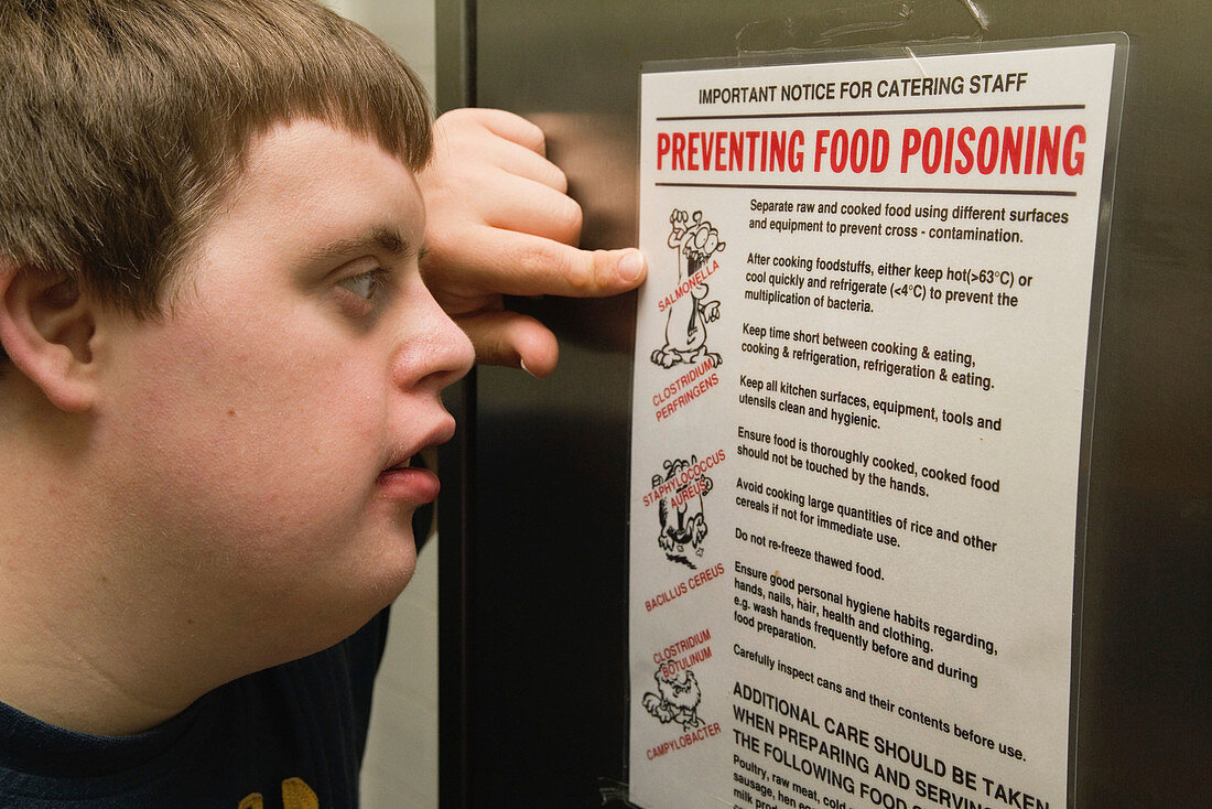 Teenaged boy with Down Syndrome reading about food hygiene
