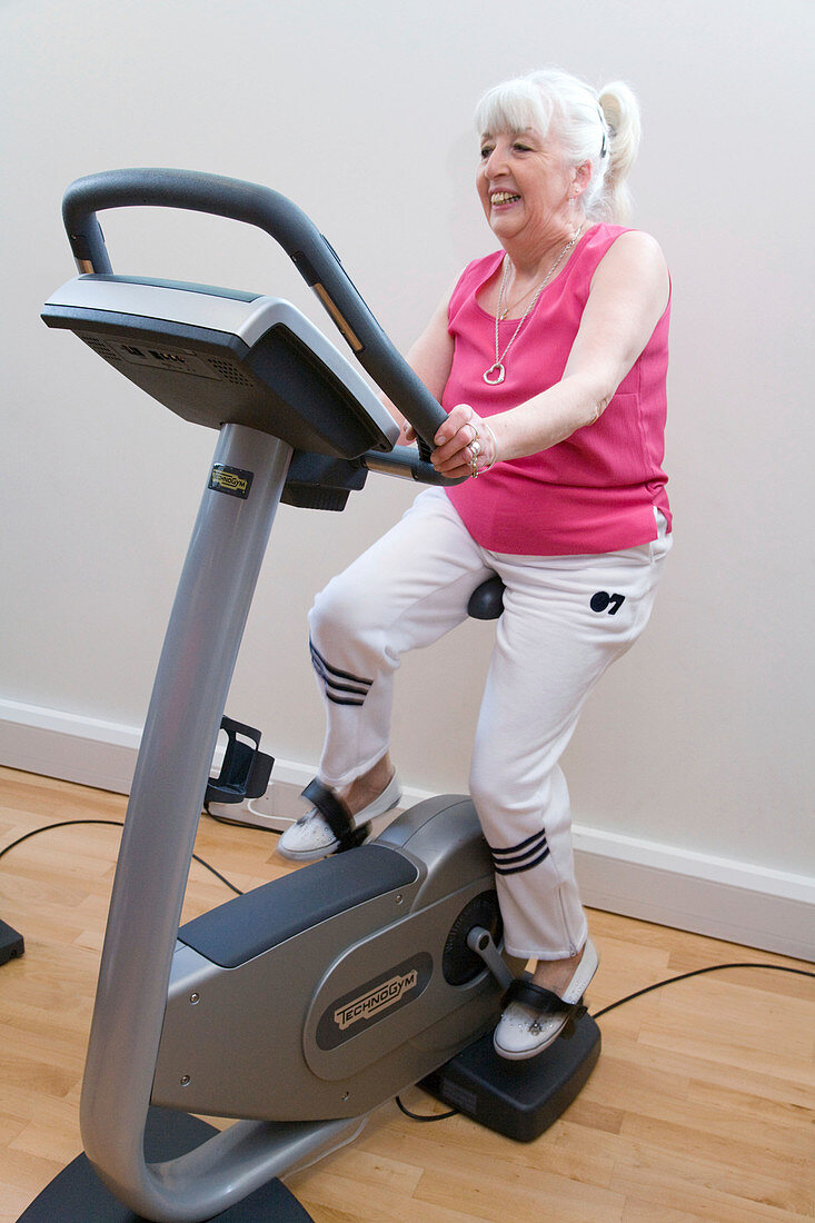 Older woman working out on exercise bikes at a gym