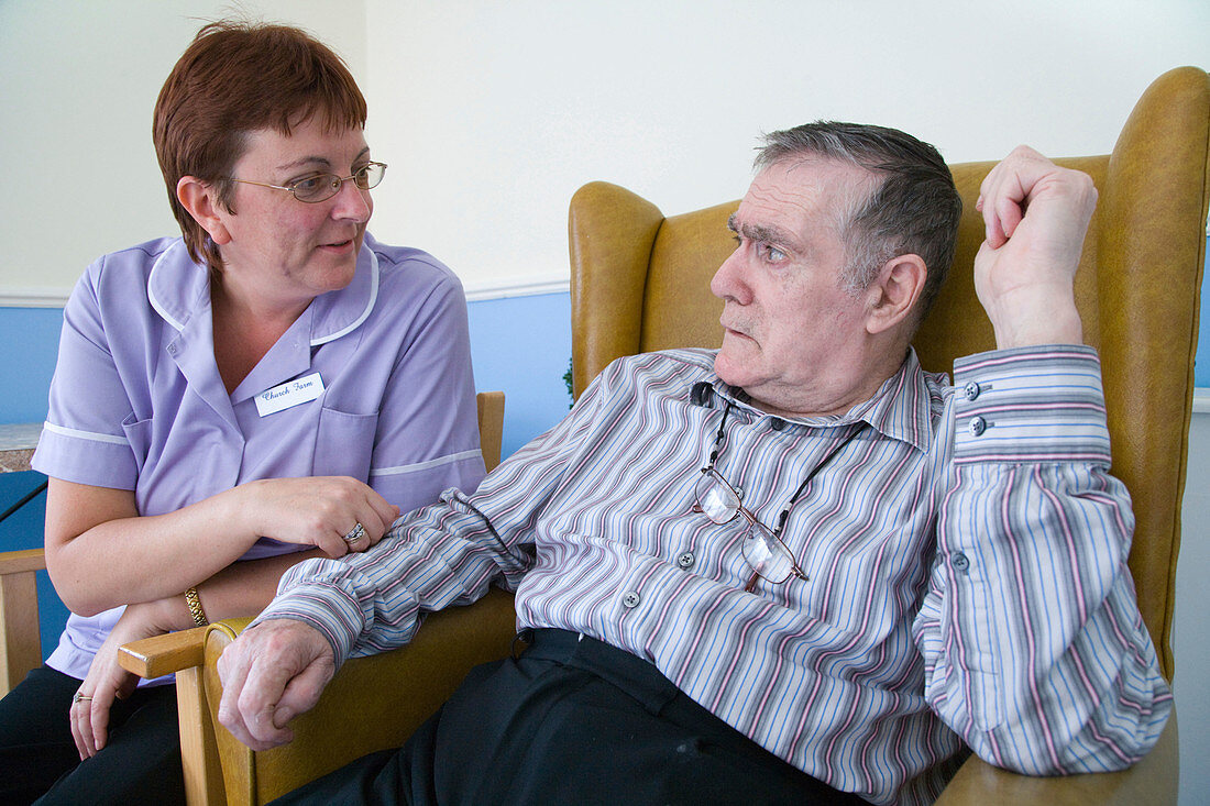 Care Assistant chatting to man with Alzheimer's Disease