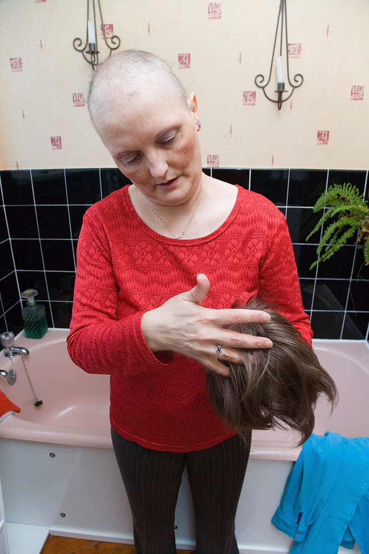 Chemotherapy patient putting on a wig