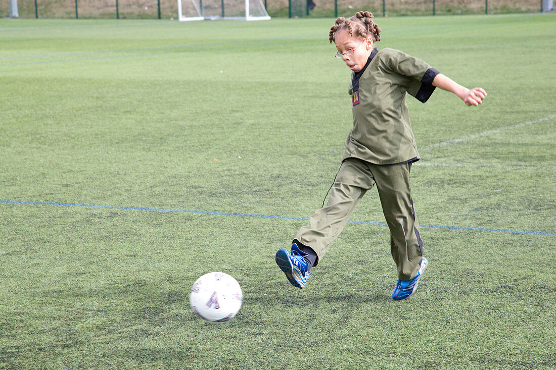 Young boy kicking a football