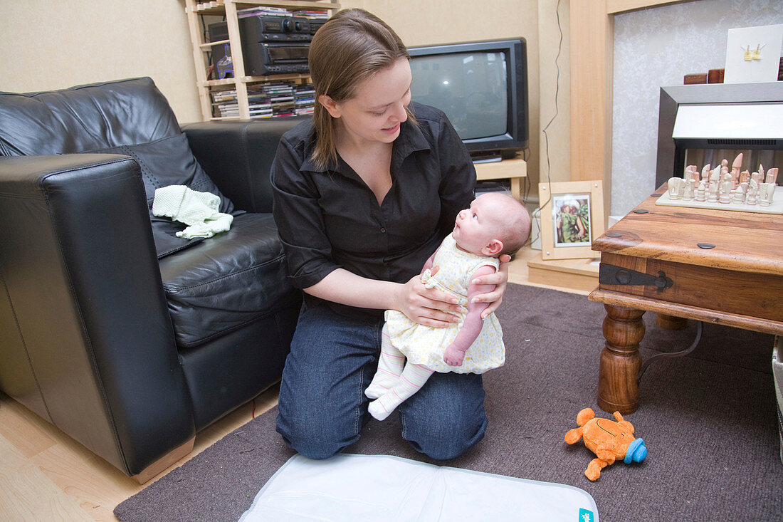 Young mother holding her five week old baby