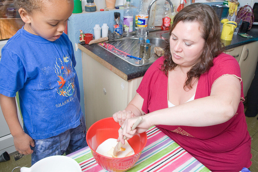 Mother and her young son baking a cake together