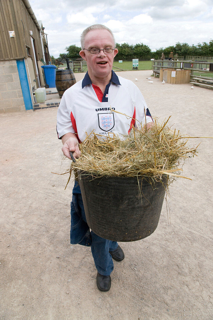 Man with learning disabilities helping to muck out a stable