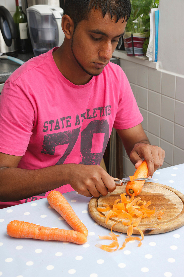 Teenager cutting carrots