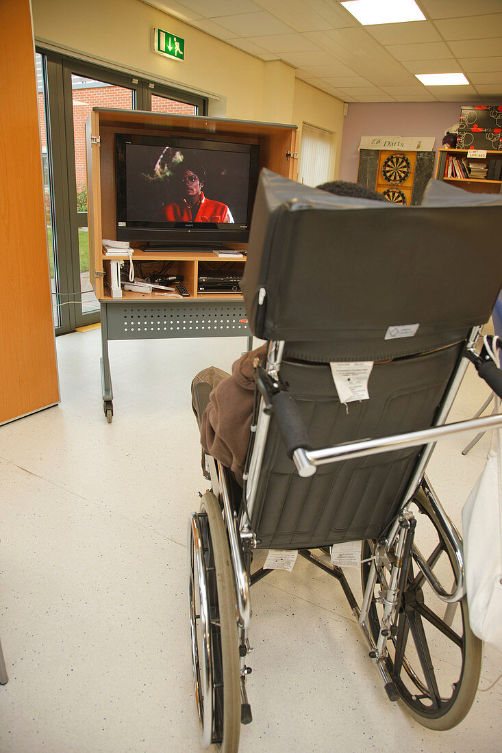 Man with advanced multiple sclerosis watching television