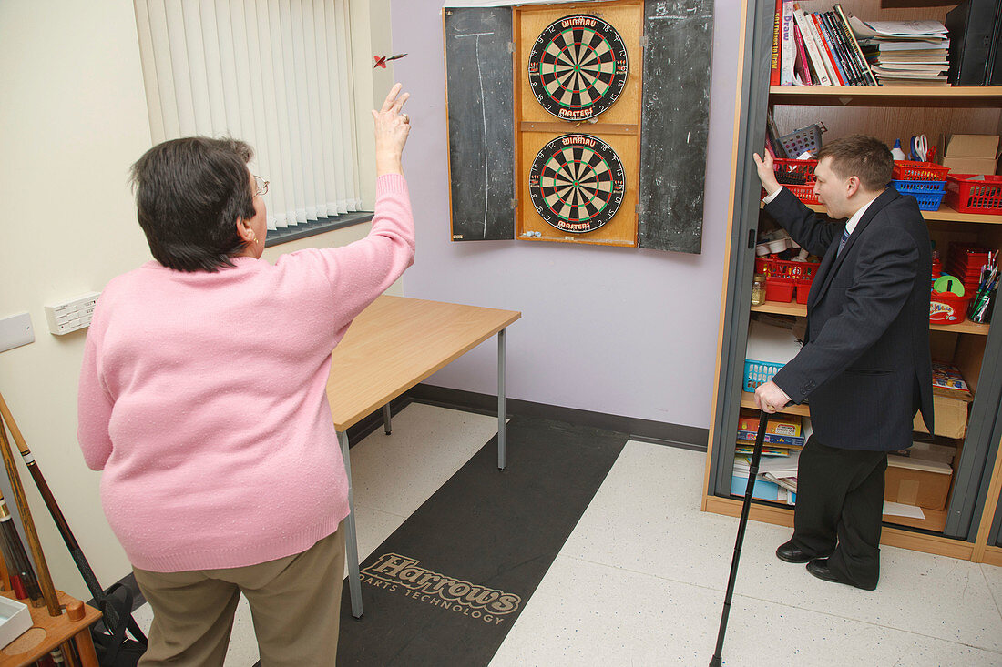 Woman with scoliosis playing darts