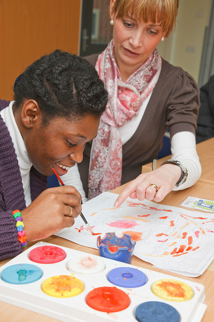 Black girl with cerebral palsy in painting class