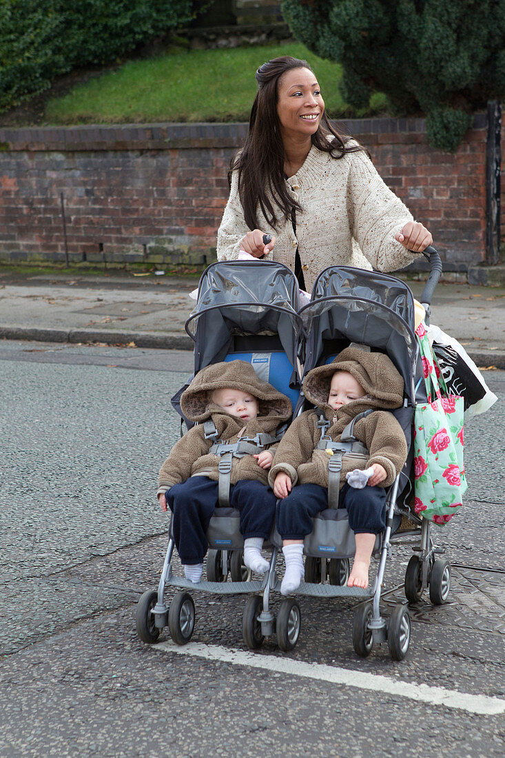 Mother crossing road with twins in buggy