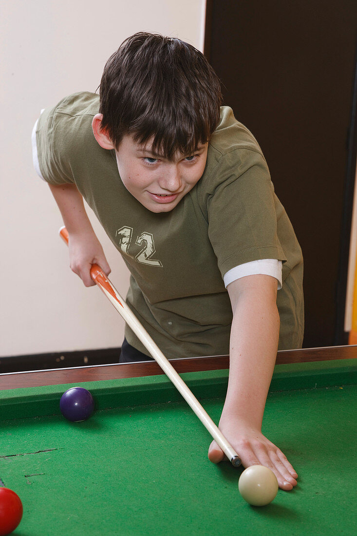 Boy playing pool in youth club