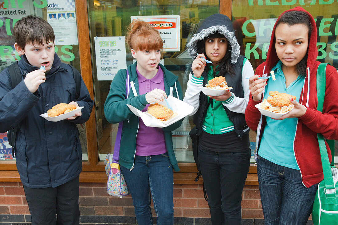 Teenagers eating fish and chips