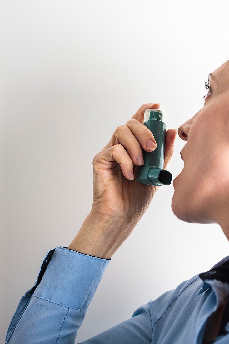 Close-up of woman using an asthma inhaler