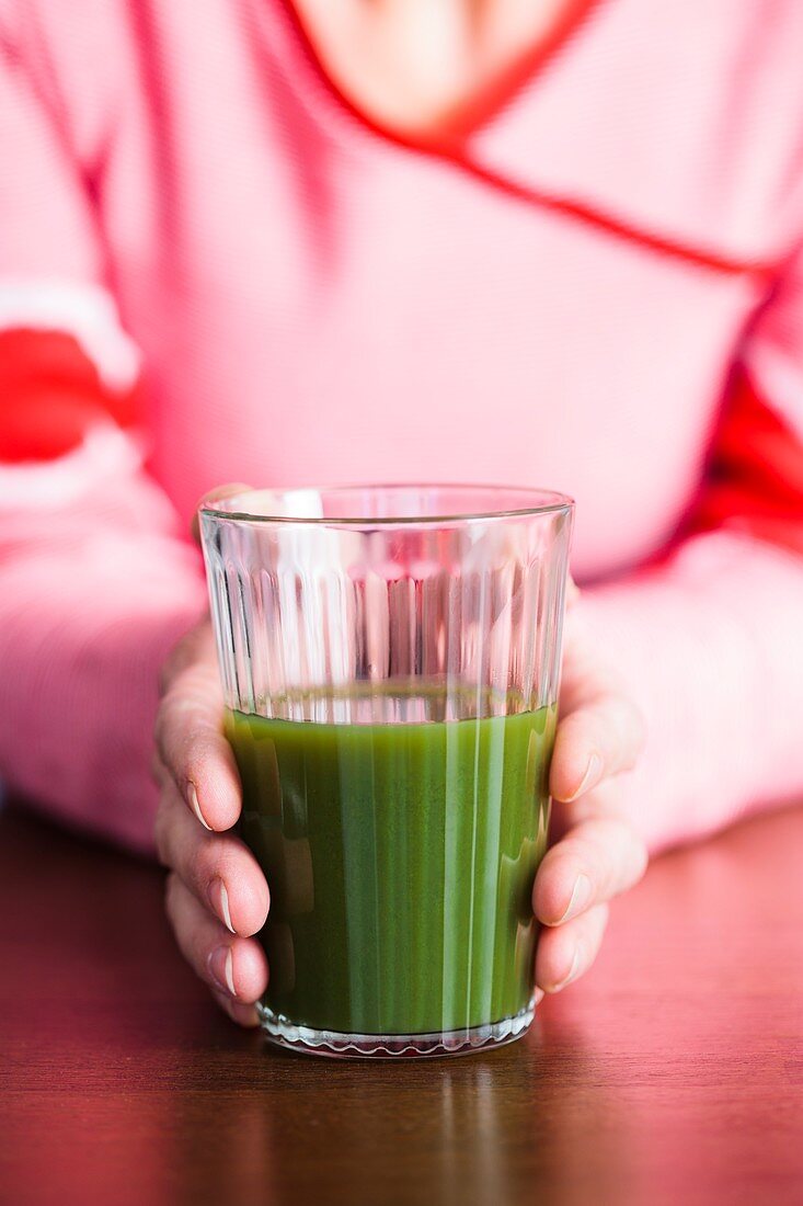 Close-up of woman holding a green juice