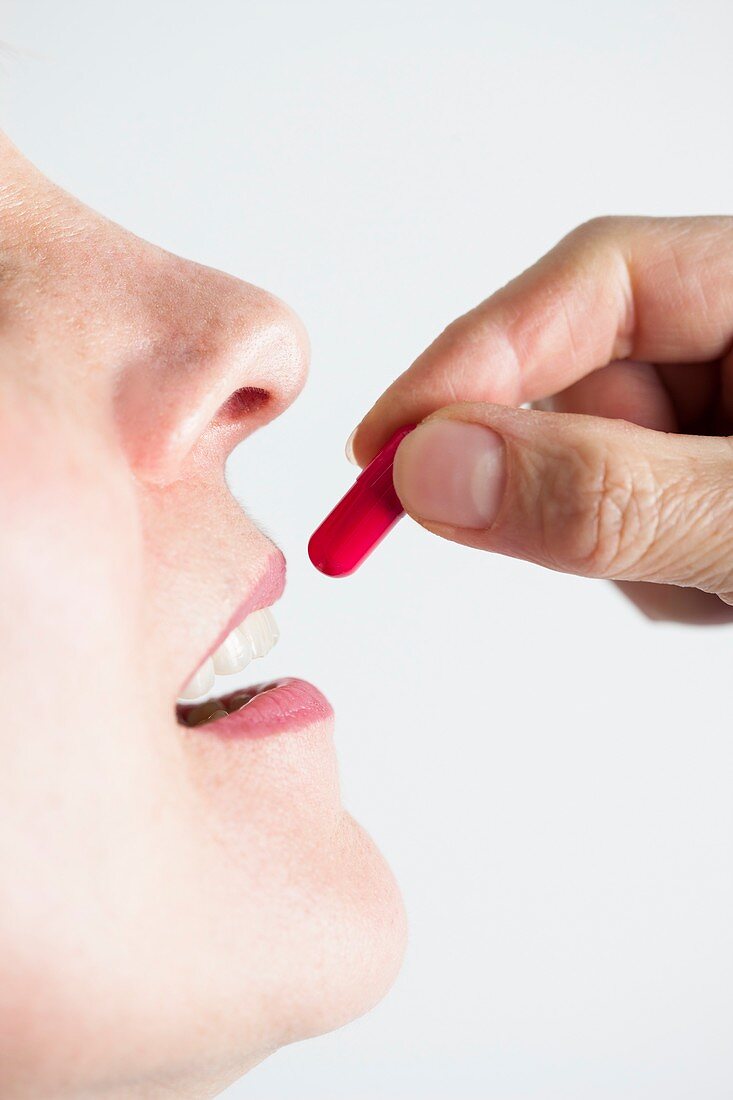 Close-up of a woman taking medication