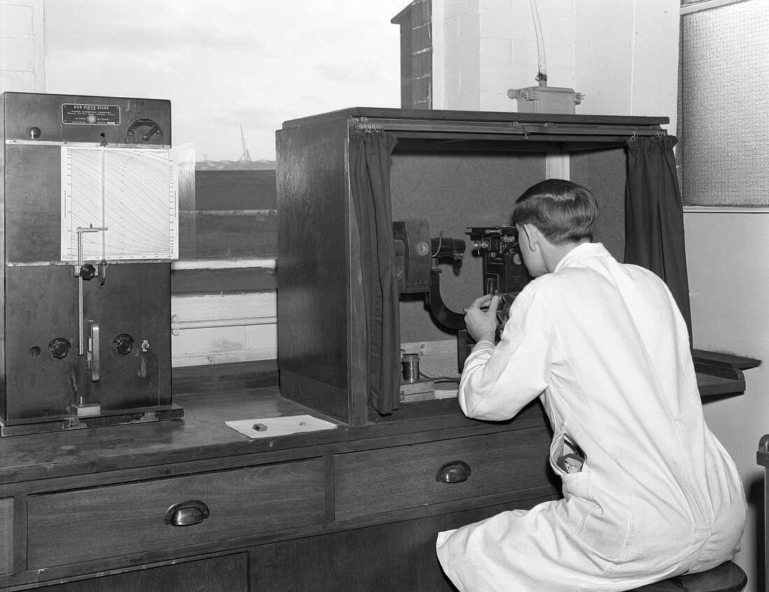 Lab technician with microscope at a steelworks, 1962
