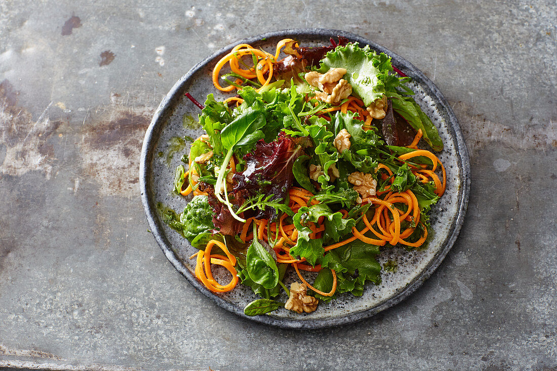 Green salad with walnuts and carrot spirals